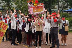 慈惠醫院鍾院長頭戴狀元財神帽子打頭陣,帶領一級主管高高舉起紅布條祝賀。